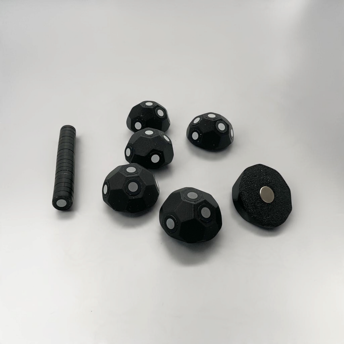 Set of black 3D scanner marker targets and discs displayed on a white background.