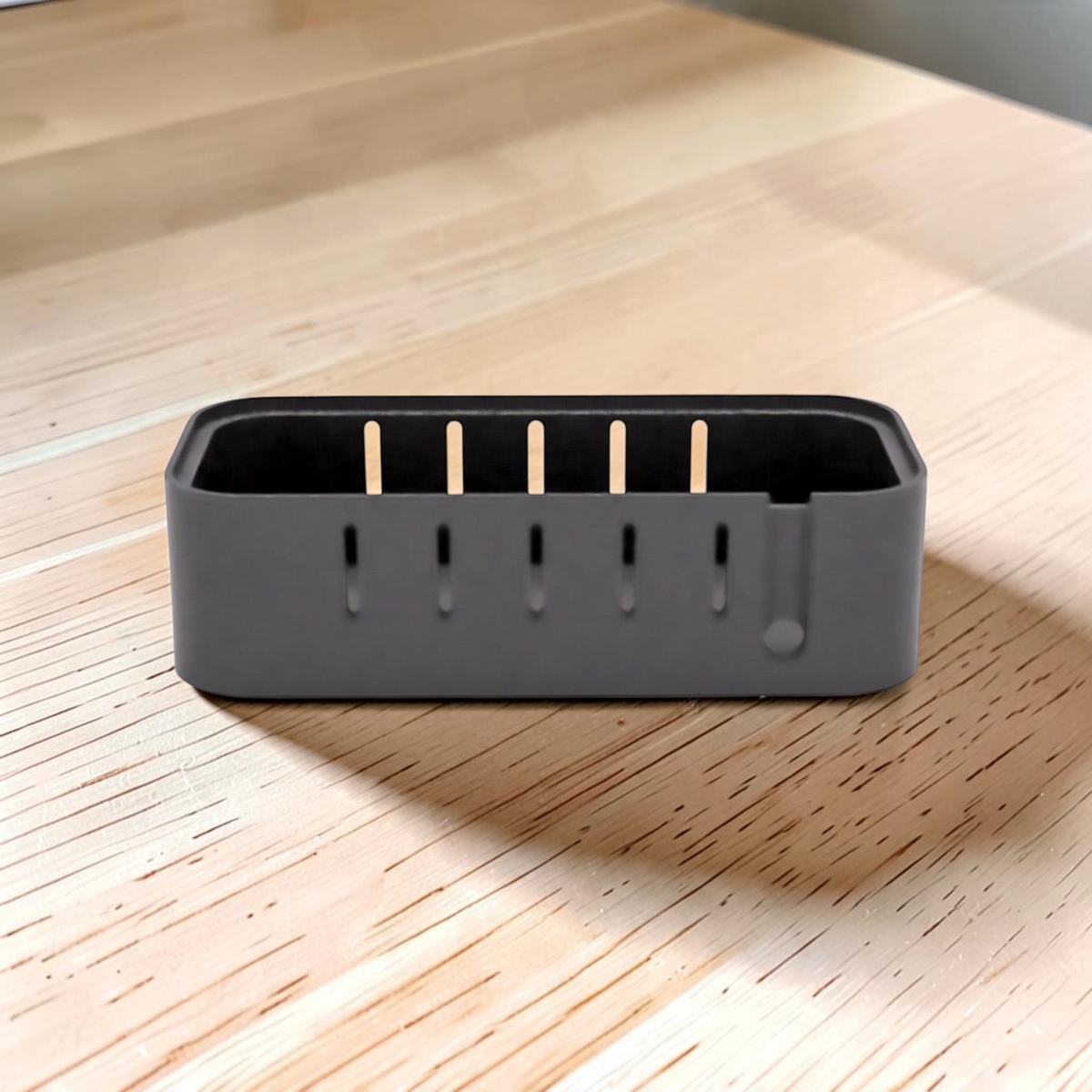 Side view of the black USB outlet enclosure with ventilation slots and port openings along the top.