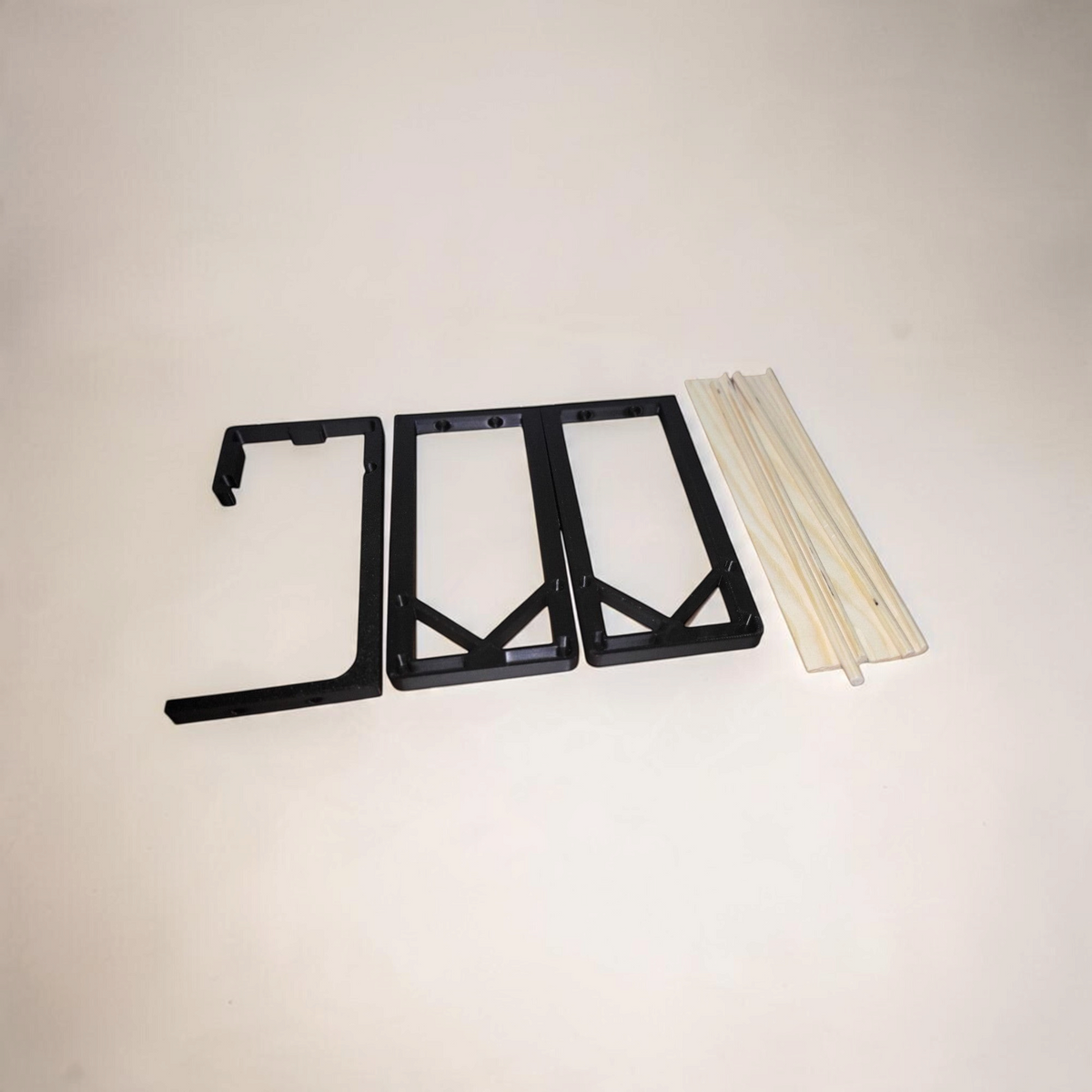 Disassembled spice rack kit showing black 3D printed brackets and separate wooden dowels before assembly.