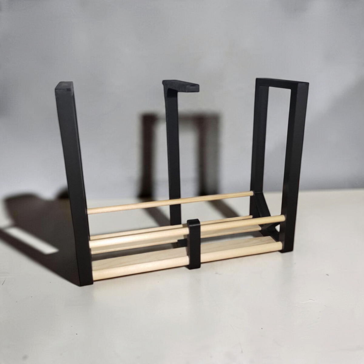 Black 3D printed rack brackets connected by wooden dowels to create customizable kitchen spice storage.