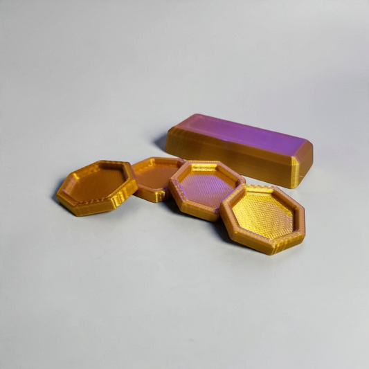 Doors Inspired set of gold colored 3D printed coins with hexagonal faces and a matching rectangular bar, arranged on a light surface.