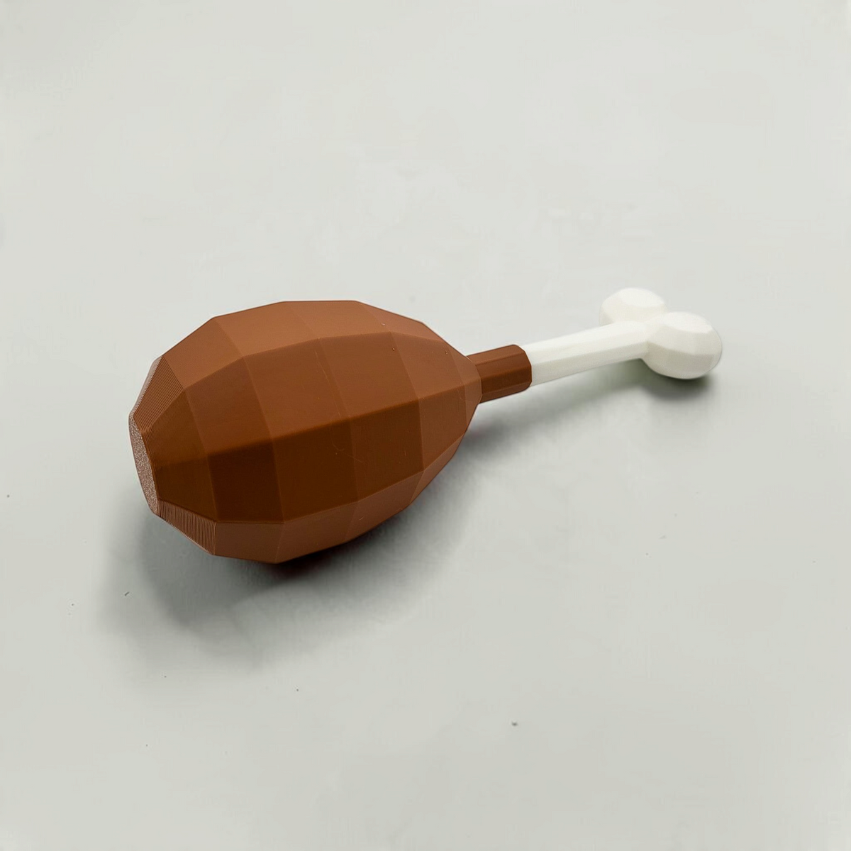Left-side view of a brown turkey leg cosmetic fan art with a white bone on a white background