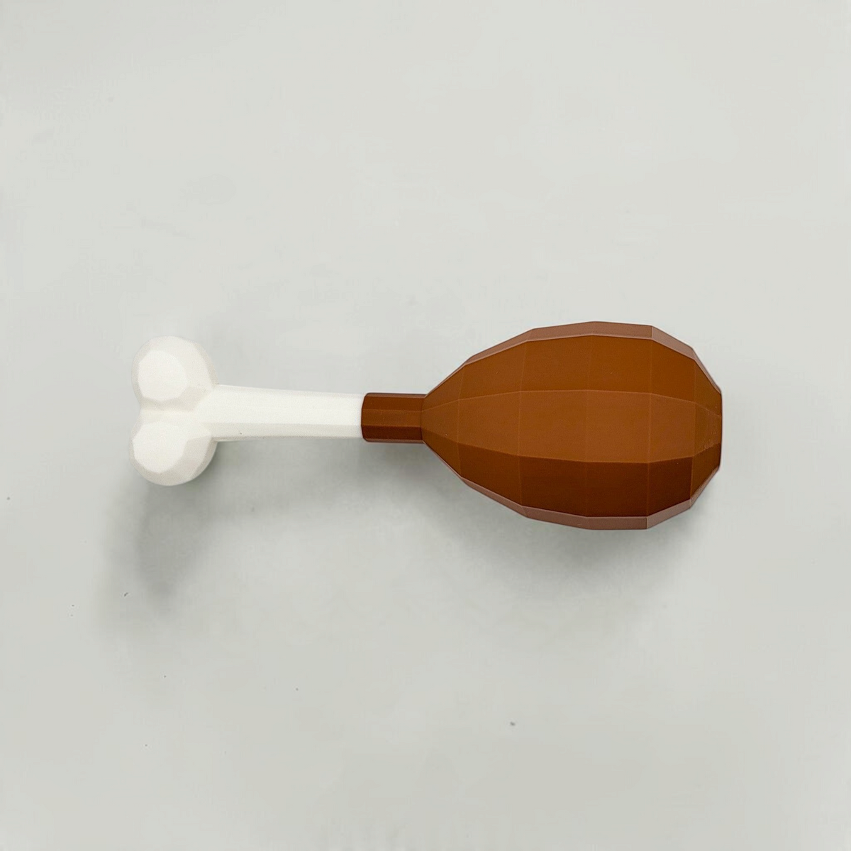Reverse view of a brown turkey leg cosmetic fan art with a white bone on a white background