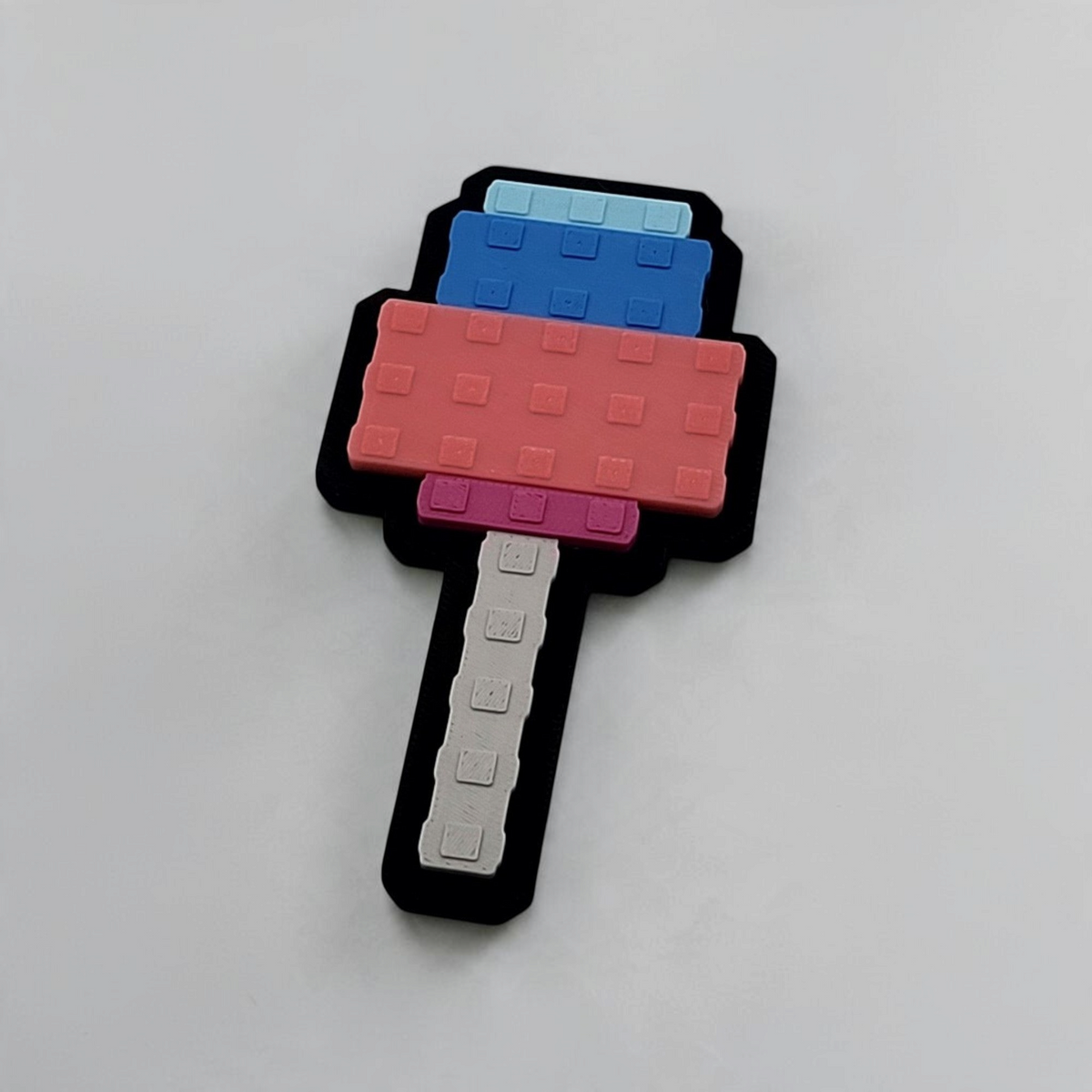 Blue and pink pixel-style Candy Blossom badge with a grey handle and black backing.
