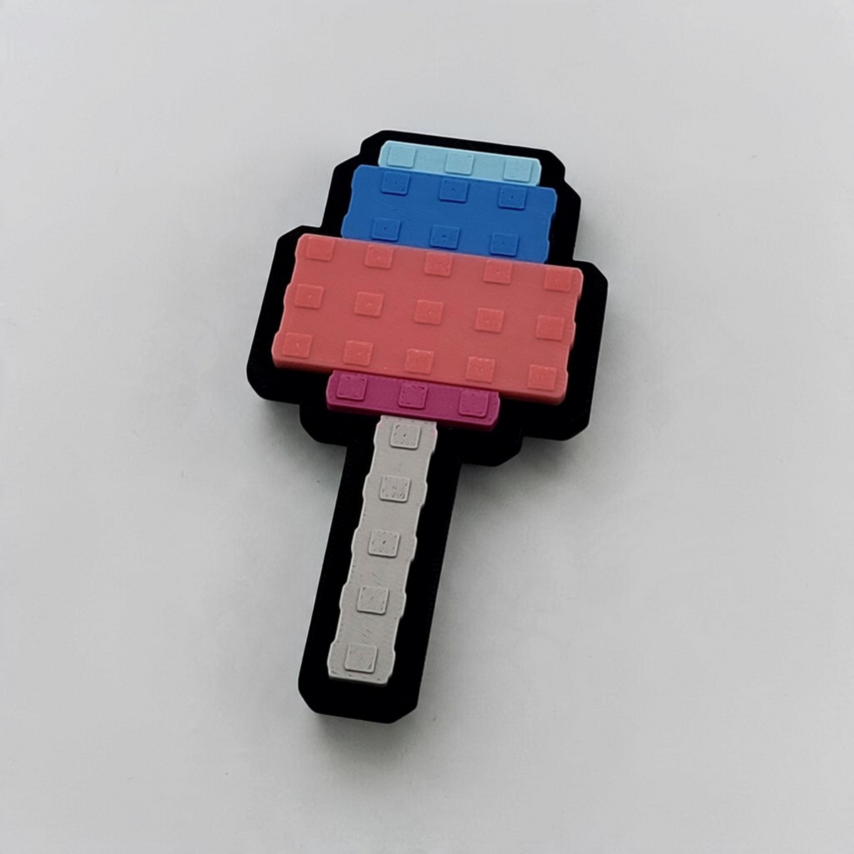 Pixel-style Candy Blossom popsicle fridge magnet in blue, pink and grey with a black magnetic backing.