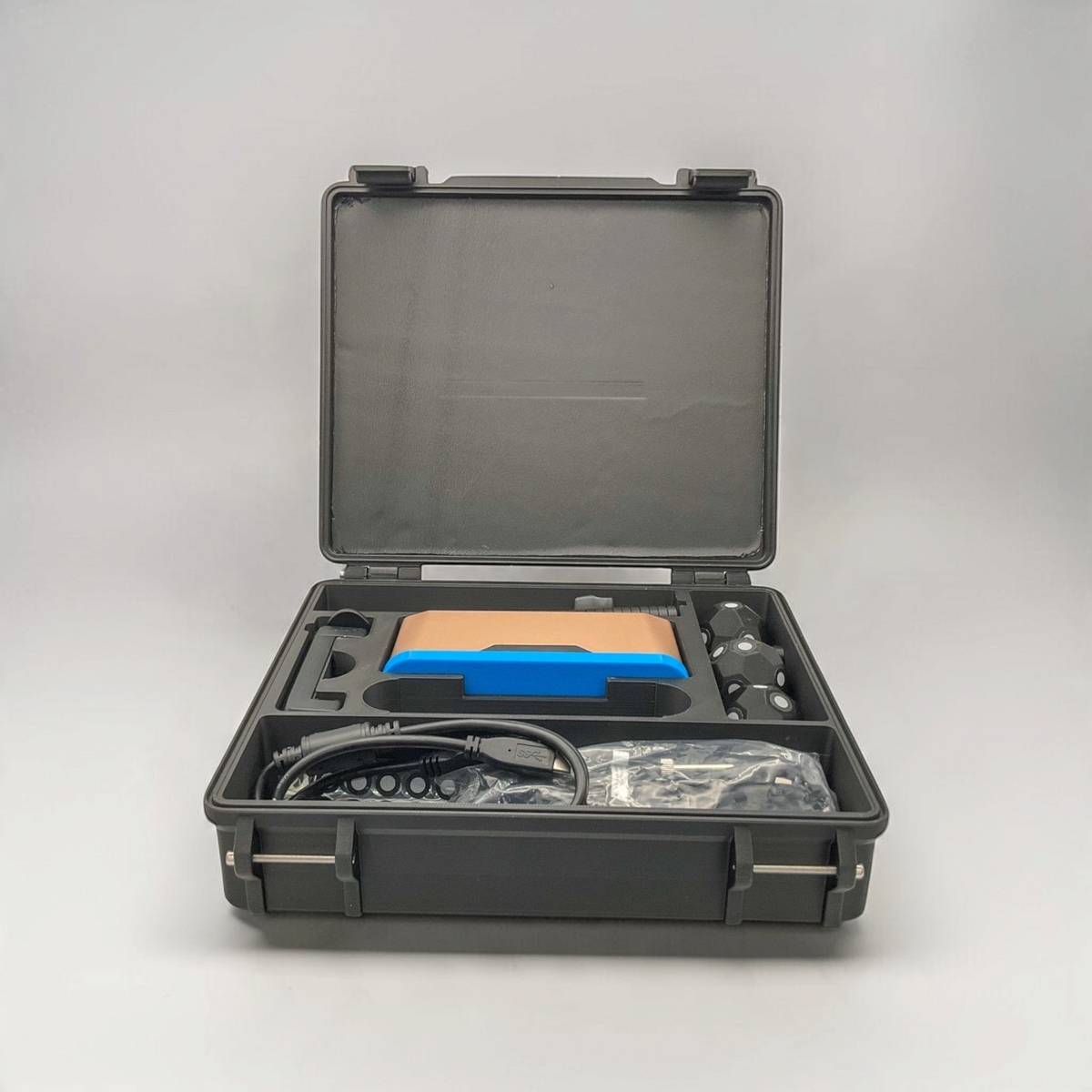 Open black protective case for the Inspire 2 scanner with foam compartments holding scanner equipment and accessories.