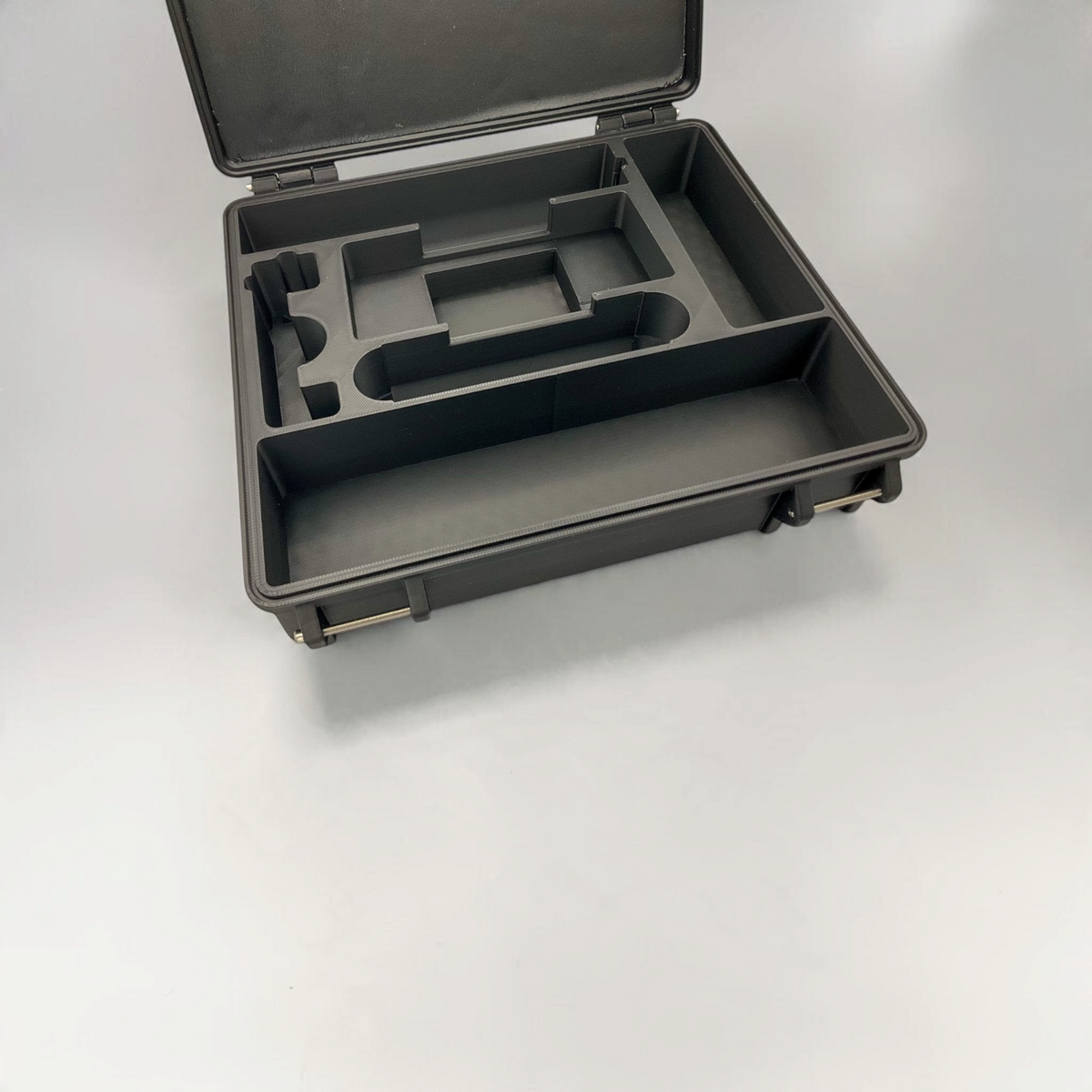 Open black scanner case with empty fitted foam compartments ready to hold equipment.
