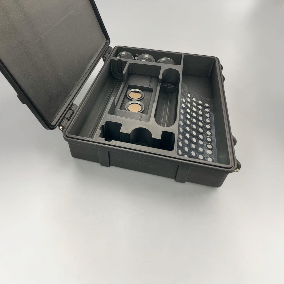 Open protective case showing a scanner and accessories arranged in custom foam compartments.