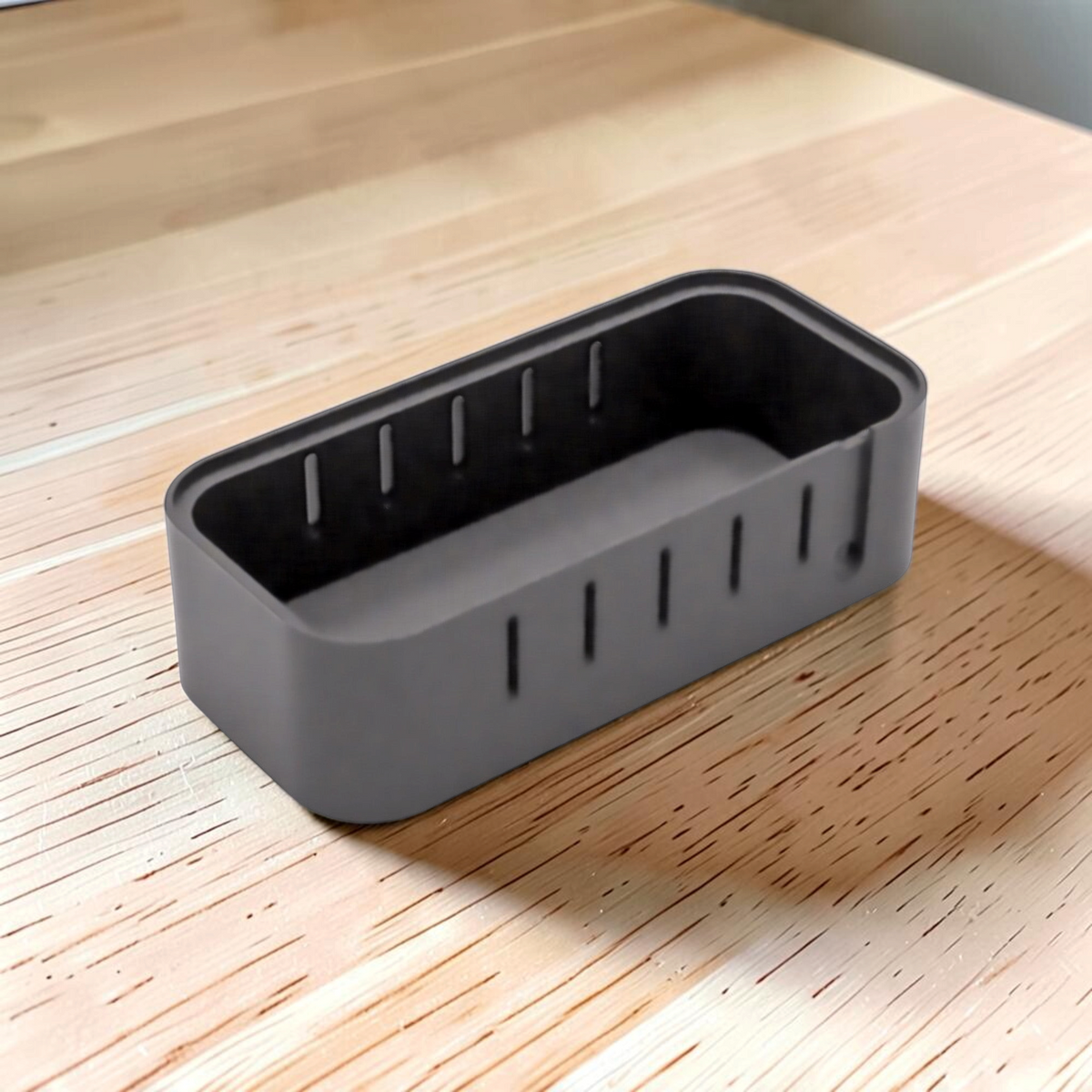 Open black 12V USB outlet case showing the recessed interior and side ventilation slots.