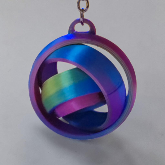 Rainbow 3D printed gyro keyring hanging from its keychain loop.
