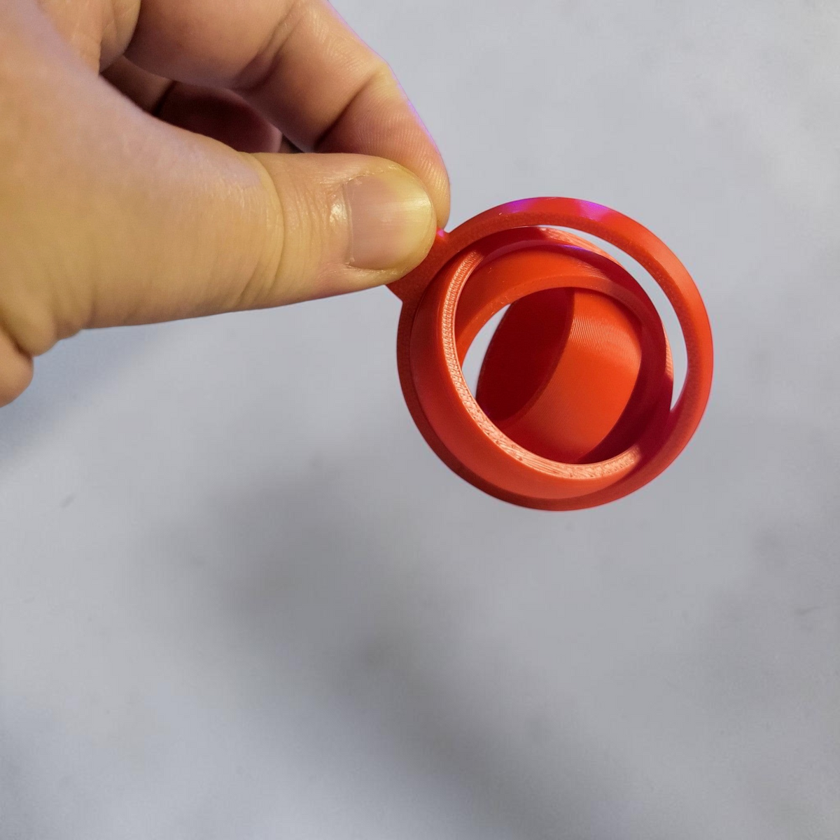 Red 3D printed gyro keyring held in a hand.